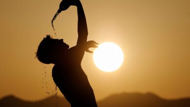 A runner cools down with water in hot weather