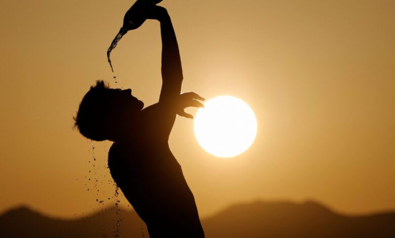 A runner cools down with water in hot weather