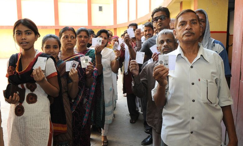 Voters standing in the queue to cast their votes at a polling booth during the 9th Phase of General Elections 2014 in Varanasi Uttar Pradesh on May 12 2014